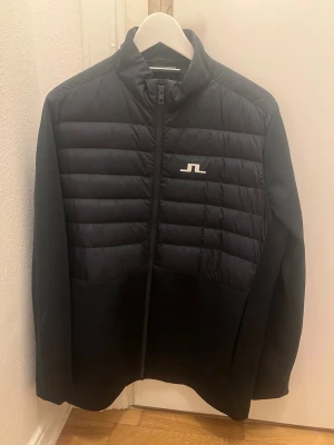 J.Lindeberg hybridjacka - Stilren hybridjacka från Jlindeberg i väldigt bra skick. Storlek L. Nypris på en sån här är ca 2 tusen kronor. KAN GÅ NER I PRIS VID SNABB AFFÄR!