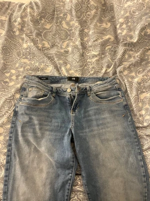 Ljusblå jeans från LTB - Säljer ett par ljusblå jeans från LTB med klassisk femficksdesign och gul kontrastsöm. Jeansen har rak passform och normal midja. Materialet är mjukt denim i bomull och de har subtila slitningar för en avslappnad look.