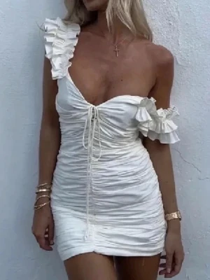 Zara strl XS (S) Vit kort med volang - Supersöt kort vit klänning med volangdetaljer på axelbanden och snörning framtill. Klänningen har en tight passform och är gjord i ett lätt, rynkat material som ger en snygg struktur. Perfekt för sommarens alla tillfällen och ger en romantisk vibe. Strl S men är liten i storleken, som en xs/32. 