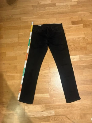 Levi's jeans - Säljer ett par svarta Levi's 511 jeans med klassisk femficksdesign och raka ben. Jeansen har en snygg, enkel look med diskret Levi's-lapp bak och röd logotagg på bakfickan. Tillverkade i mjukt jeansmaterial som sitter riktigt bra.