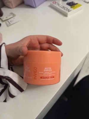 Wella Invigo Nutri Enrich hårmask - En orange burk med Wella Invigo Nutri Enrich hårmask, berikad med gojibär. Masken är framtagen för torrt eller stressat hår och ger intensiv näring. Perfekt för dig som vill boosta håret med extra fukt och glans nu under vintern. Säljer då jag fick fel vara den är oöppnad och helt ny. 
