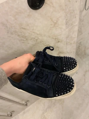 Louboutin i mocka  - Mörkblåa Louboutin i mocka i bra skick. Skorna är storlek 41 men sitter lite större så passar också 42. Skorna är äkta men det är bara skorna som ingår därför lite billigare pris. Hör av er vid frågor!