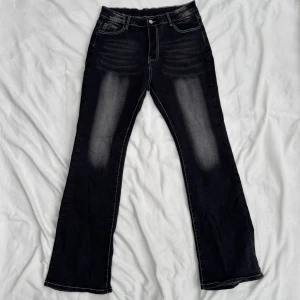 Svarta bootcut jeans - Svarta jeans med vit kontrastsöm och snyggt broderade bakfickor i vitt mönster. Stretchiga. Aldrig använda, i storlek XL. Fraktar inom 24h!