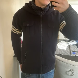 Stickad cardigan med luva - Otroligt snygg stickad cardigan med luva. Passar perfekt till kallare väder. Modellen är 180cm, 73kg. Priset går att diskutera så skicka gärna iväg ett prisförslag! 