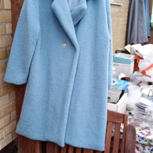 Ljusblå teddyjacka från SHEIN XL - Säljer en oversized ljusblå teddyjacka från SHEIN i storlek XL. Jackan har bred krage, långa ärmar och stängs med knappar framtill. Mjuk och fluffig känsla med slät insida, perfekt för kyliga dagar. Enkel och stilren design som ger en chill vibe.