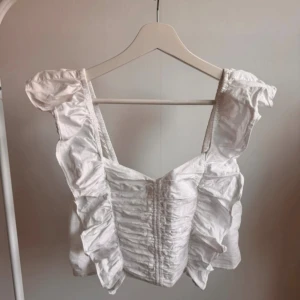 Vit topp i linne-look från HM - Vitt linne från HM. Storlek M. Väl använd men fortfarande i bra skick.