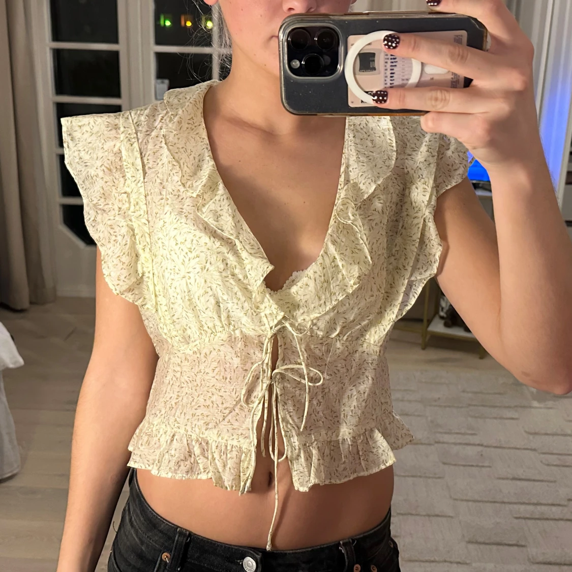 Blommig blus med volanger och snörning