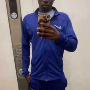 Blå Nike zip-tröja med lång ärm - Säljer en blå långärmad zip-tröja från Nike med vit logga på bröstet. Tröjan har hög krage och dragkedja framtill, perfekt för träning eller sportiga outfits. Snygg och sportig design som passar dig som gillar en aktiv stil.