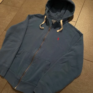 Zip från Ralph Lauren - Blå (Herr M/S - Riktigt snygg zip från Ralph Lauren. Tröjan är i gott skick i storlek L men passar som M/S. Nypris ligger runt ca 2200kr
