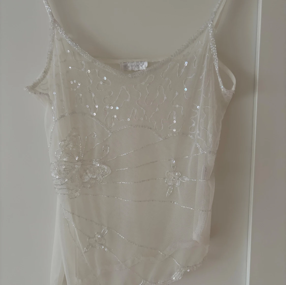 Vit paljettprydd linnetopp