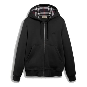 Svart hoodie från Burberry - Svart hoodie från Burberry med dragkedja, huva med snörning och klassiskt rutigt foder. Tröjan har två stora fickor framtill och diskret Burberry-logga på bröstet. Perfekt för dig som gillar stilren design med en touch av lyx.