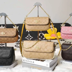 C axelväska med kedja och logomönster - Snygg axelväska från Coach med kedjerem och klassiskt logomönster. Finns i flera färger som beige, brun, svart och rosa. Väskan har guldfärgade detaljer och är tillverkad i skinn och syntet. Perfekt storlek för det viktigaste och en stilren look.