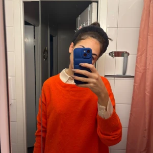 Oversized orange stickad tröja - En riktigt snygg oversized stickad tröja i klar orange färg. Tröjan har rund halsringning och långa ärmar med breda muddar. Perfekt för lager-på-lager och ger en poppig vibe till din outfit.