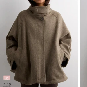 Beige kappa med hög krage - Snygg beige kappa i ull med oversized passform och hög krage med knappar. Säljer för att den inte kmr till användning❤️köpte för 1000kr