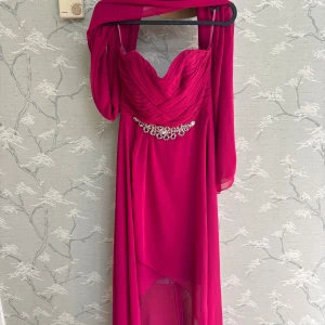 Mörkrosa långklänning med pärldetalj - Säljer en elegant mörkrosa klänning med axelbandslös  och vackert draperad överdel. Ingår matchande sjal.