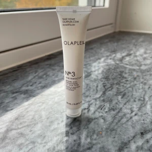 Olaplex No.3 Hair Perfector 20ml - Olaplex No.3 Hair Perfector i en smidig vit tub på 20 ml. Perfekt för att stärka och reparera alla hårtyper. Tuben är lätt att ta med och har minimalistisk design med svart text. Innehåller vårdande ingredienser för att boosta hårets styrka.
