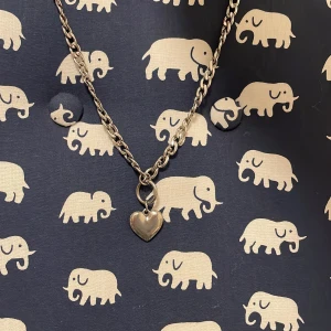 Halsband med hjärta - Kedjehalsband i silverfärg med ett blankt hjärthänge. Kedjan är lite grövre och ger ett coolt intryck, perfekt för att lyfta din outfit. Hjärtat är slätt och stilrent, vilket gör halsbandet lätt att matcha med andra smycken.