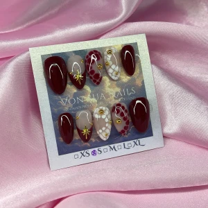 Bordeaux (S);Short Almond;Curved - Handgjorda press-on naglar i kort mandelform med bordeauxröd, nude och vit design. Dekorerade med guldiga stenar, stjärnor och prickmönster. Mix av designe för en unik look. Perfekt för dig som vill ha snygga naglar snabbt.S: 15 mm, 11,5 mm, 12 mm, 11 mm, 9 mm 