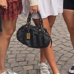 Marc Jacobs väska - Nu säljer jag min otroliga Marc Jacobs väska som passar till allting! Jag har använt den mycket men är fortfarande i väldigt bra skick, skriv privat för fler bilder 🫶🏼 Det tillhörande axelbandet följer inte med. Säljer den för 2500 kr❤️