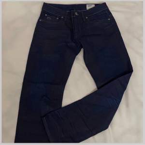 Ett par mörkblåa jeans från G-STAR.                                   De är använda endast 1 gång.                                           Storleken är L30 W32                                                                     Frakt tillkommer!