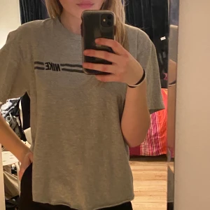 Nike t-shit - Snygg grå Nike t-shirt i vintage stil. Plagget är i storleken M men har klippt av den så att den inte har längden som en M. 