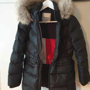 Tommy Hilfiger Down coat - Varm vinterjacka med pälskrage i strl 152. Använd ett fåtal ggr så den är i jättefint skick då vi köpte fel strlk. 