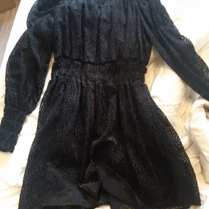 Mjuk Svart Halloween/Nyår Klänning  - Säljer en snygg och läcker höstig klänning 🎃 En liten knapp i halsen ♡ Stretchig, lång, dekorativt tyg och super mjuk 💯 Aldrig använd men kände inte att den passa mig ändå. Snyggt till nyår 😘