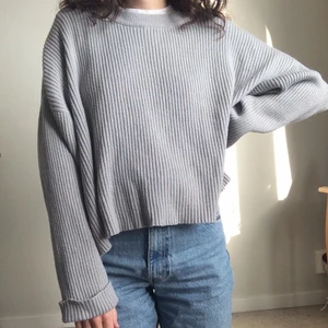 Ribbstickad tröja - Grå, ribbad, ganska bred stickad tröja, lite croppad. Strl L. Köpt 2nd hand men ursprungligen från BikBok. Bra skick, knappt använd av mig.