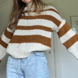 Mysig stickad tröja  - En supermysig randig stickad tröja från NA-KD. Den är vit/beige och brun. Storlek xs. Bra skick lite nopprig. Väldigt lång i ärmarna. Köparen står för frakten.
