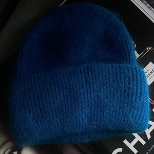 Blå stickad mössa - Superfin mössa köpt på ByAnastasia. Säljer då den inte kommer komma till användning 🤍 Köpt för 350kr inklusive frakten ☺️ aldrig använd! 