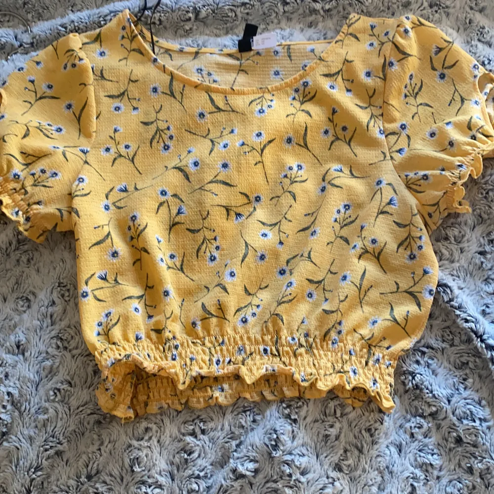 Gul blus/t-shirt med blåa blommor storlek: XS ville också säga att ifall frakten blir dyr så behöver man bara betala för frakten detta gäller alla plagg så slipper det bli dyrt för de som köper<33. Puserot.