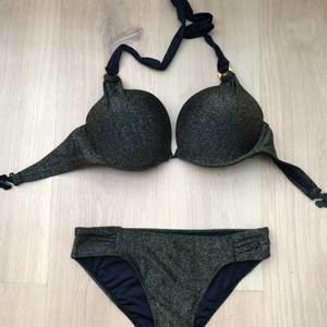 Black bikini with golden glitter on it. I never wore it but I removed the tag. The top is 75D the bottom is S
