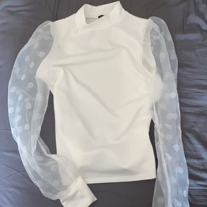 Vit topp i storlek 36 - Fin vit topp från boohoo i storlek 36. Prickar på armarna. Bra skick använd 2-3 ggr. 