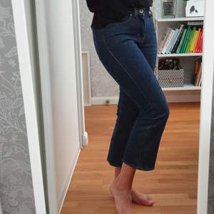 Mörkblå jeans från Tiger storlek 24/30. Utställda ben från knät och croppade. Jag tycker de känns större än 24 i midjan, jag brukar ha 25. Väldigt sparsamt använda. 