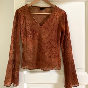 Blus/topp - Fin topp med utsvängda ärmar i rostig orange färg! Är i mesh men har ett undertyg framtill, köpt secondhand och står stl 38/40 men passar mig som brukar ha XS/S 🧡