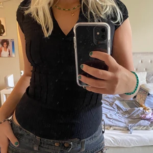 Svart topp - Jättesöt svart topp! Köpt second hand men knappt använd. Den sitter tajt och är v ringad samt har en väldigt liten puffärm! 💕 passar bra till lågmidhade jeans😃