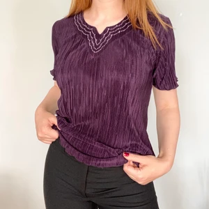 Unik topp perfekt till hösten - V-ringad topp i en superhärlig mörk lila färg med vågig rullfåll och små små pärlor runt urringningen • från Sara Louise i storlek M • i använt men fint skick • perfekt till hösten med instoppad i ett år höga 70-talsjeans • frakt på 48kr tillkommer :) 