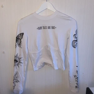 Tröja Bershka - Tröja med detaljer under byst och tryck på ärmar. Endast använd en gång. Köparen står för eventuell frakt💕