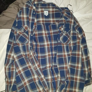 vintage skjorta - Jättefin vintage skjorta. köpt från vintage butik men har aldrig kommit till användning. vill egentligen inte sälja men känns så onödigt att ha kvar när den aldrig används. Märket är Bomerang någonting finns på bild. Storlek 44 o passar mig bra som har storlek S. Den är mörkblå och brun med en gnutta rödaktig färg i det bruna men mest åt det bruna hållet. Inga fel på den. Frakt tillkommer. Pris kan diskuteras vid snab och enkel affär. 