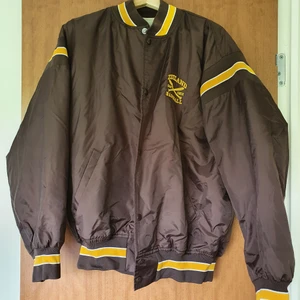 Collegejacka - Fräsch Collegejacka i brunt med gula och vita detaljer. Oversize modell, perfekt för en längd mellan 164-175 cm. 