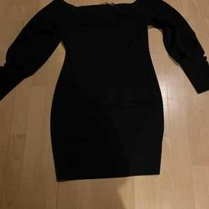 Svart klänning - - Storlek 38 - Köptes från booho - Endast använd fåtal gånger max 2 gånger  - Skönt material - Kort svart klänning som är off shoulder med 5 små knappar på ärmen  - I bra skicka 