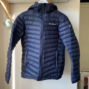 PeakPerformance dunjacka - Säljer en tunn dunjacka från PeakPerformance pågrund av att den är lite för liten för mig. Den är i storlek xs/s/160. I övrigt väldigt gott skick och inga flaws eller andra defekter finns på jackan. Luvan är avtagbar. 