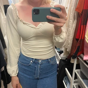 Topp - Säljer denna fina topp från Nelly, använd 1 gång så i mycket bra skick, detaljer som framhäver bysten 