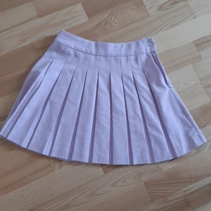 Ljuslila tenniskjol - Ljuslila tenniskjol med dragkedja i kanten. Inte använd mycket så i fint skick!