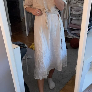 Vit kjol - Säljer denna vita kjol, det är knappar på sidan som man kan välja att ha knäppta elr mod slitts, perfekt strandkjol! Stolek xs:)