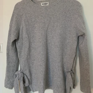 Kashmirtröja - Grå Kashmirtröja ifrån soft goat med knytningar på sidorna, storlek S. Varsamt använd är i bra skick! Säljer för 300kr + frakt😊