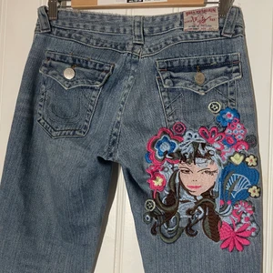 True religon jeans med tryck - Säljer mina rare true religion favorit ljusblåa lågmidjade byxor med tryck då de är för små för mig :( använda max 3 gånger av mig. Midjemåttet är ca 75 cm! Om många är intresserade blir det budgivning<3