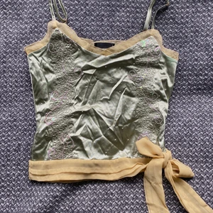 Ljusgrön paljetttopp - Ljusgrön tppp med knytning och dragkedja💚 Inköpt på second hand och knappt använd. Den är inte strykt på bilderna! Jättefina mönster med paljetterna :)