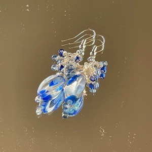 Handgjorda örhängen  - Ett par handgjorda örhängen med blå glaspärlor i olika nyanser och silvrig ståltråd!!!! Ca 4 cm med en kedja som bas :)  ************************** Kolla gärna in min profil där jag har en massa mer smycken utlagda!! Frakt ingår i priset, perfekta för dig som vill sätta en personlig prägel på stilen eller att ge bort i present 🔮💕🧿