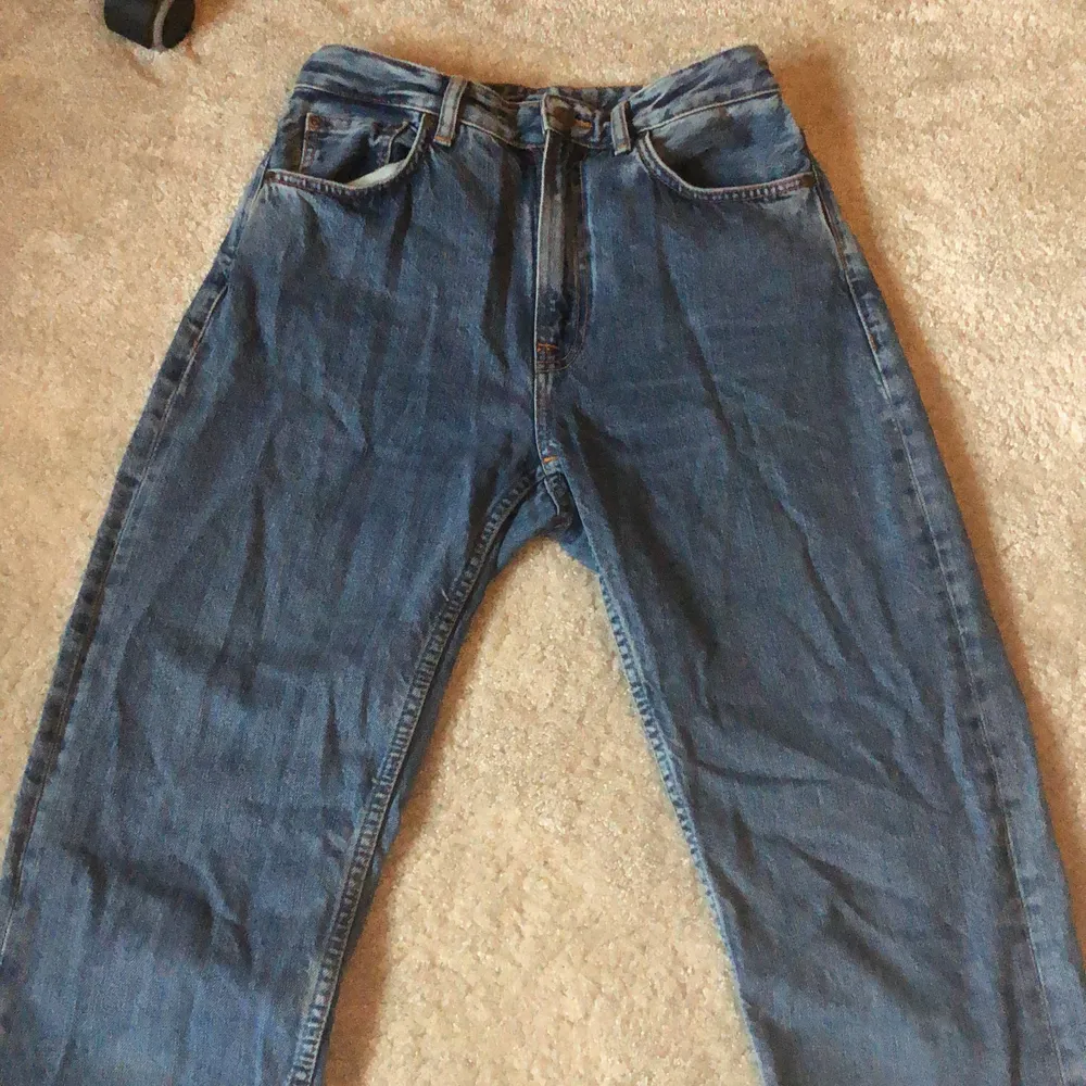 Byxorna är från märket nudie jeans. Det är storleken W28 L32. Det är en ljusare blå färg med orange detaljer och knapparna är en fin bronsig färg.. Jeans & Byxor.